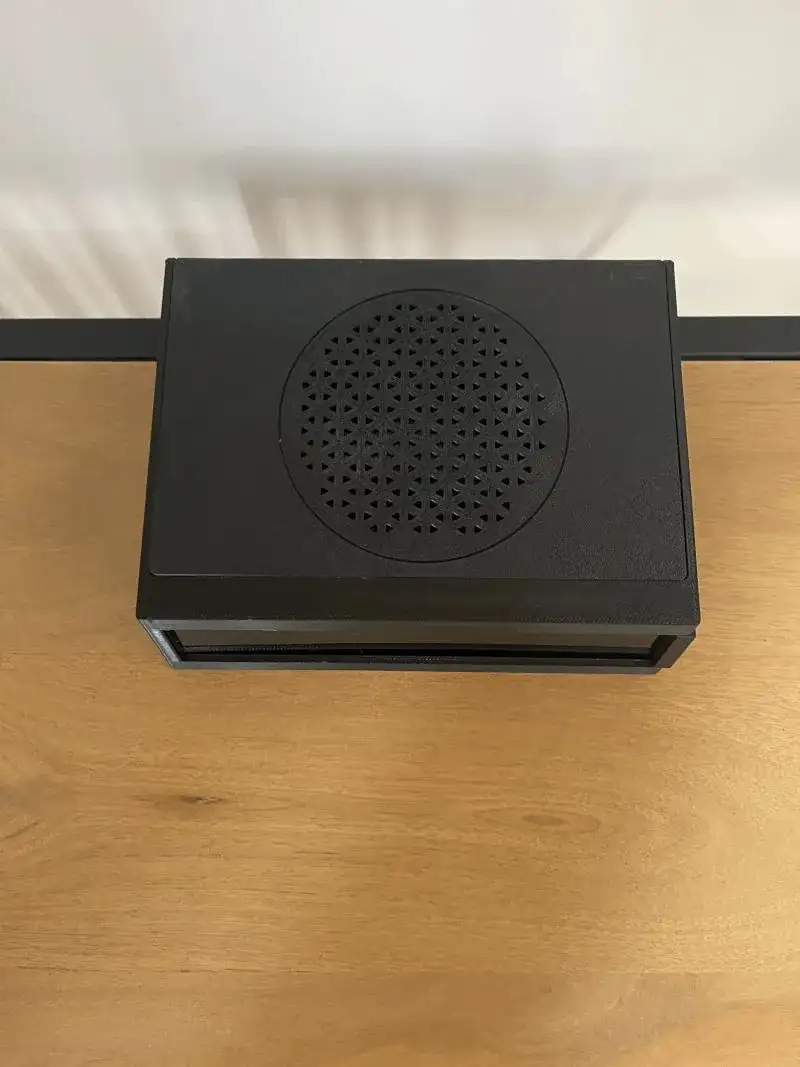 The finished black enclosure on a wooden desk.