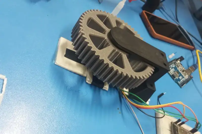 The printed gear stage under test, wired to a microcontroller board.